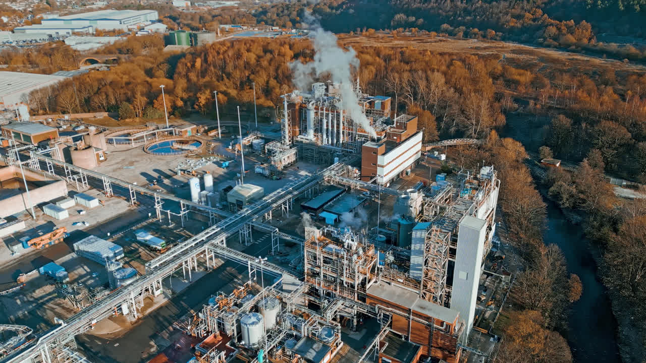 кадры с воздуха, движущиеся к большому промышленному химическому заводу, показывают трубопроводы, металлические конструкции, градирни и хранилища химикатов