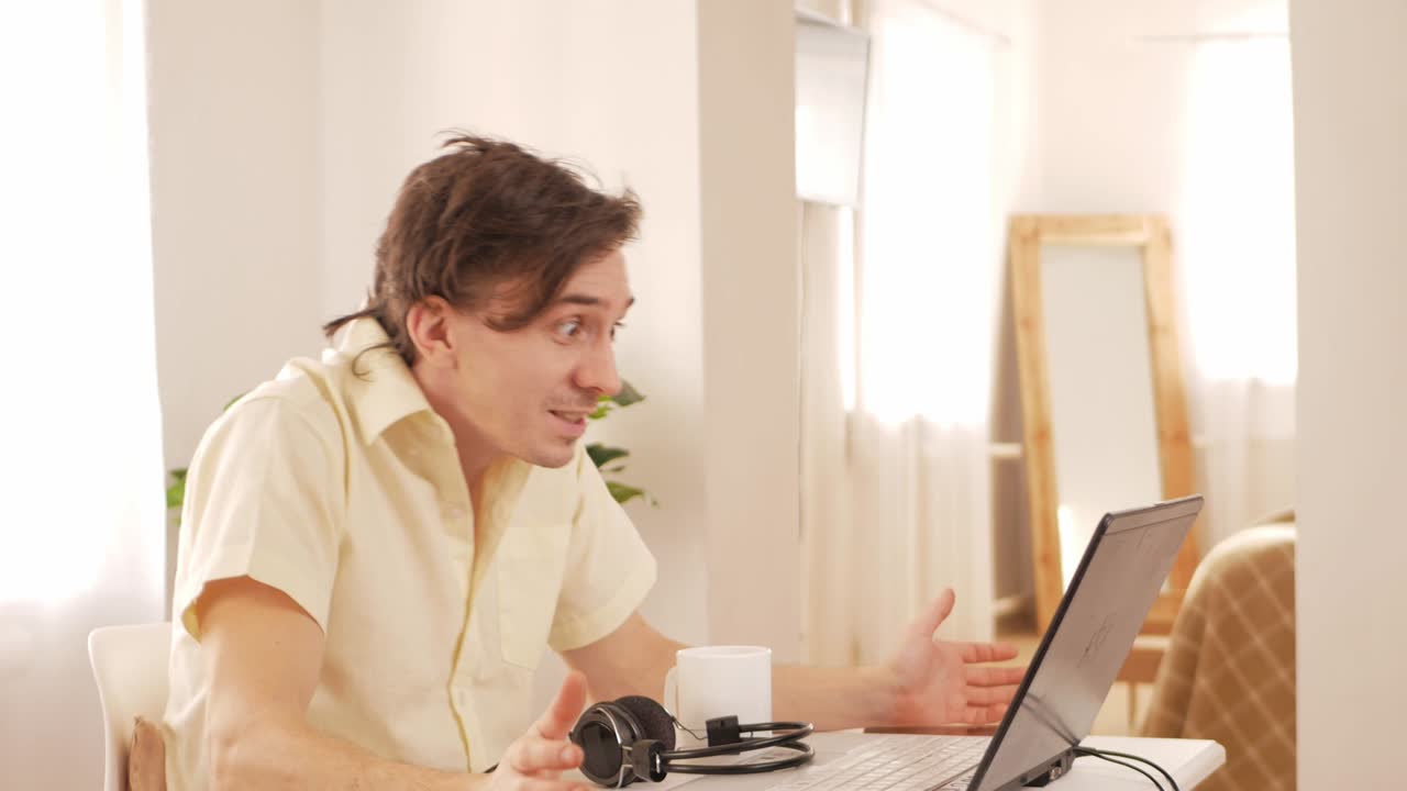 young man at home works with laptop, cryptocurrency, stock market. market is falling, collapsed, currency has fallen in value, shock, horror.