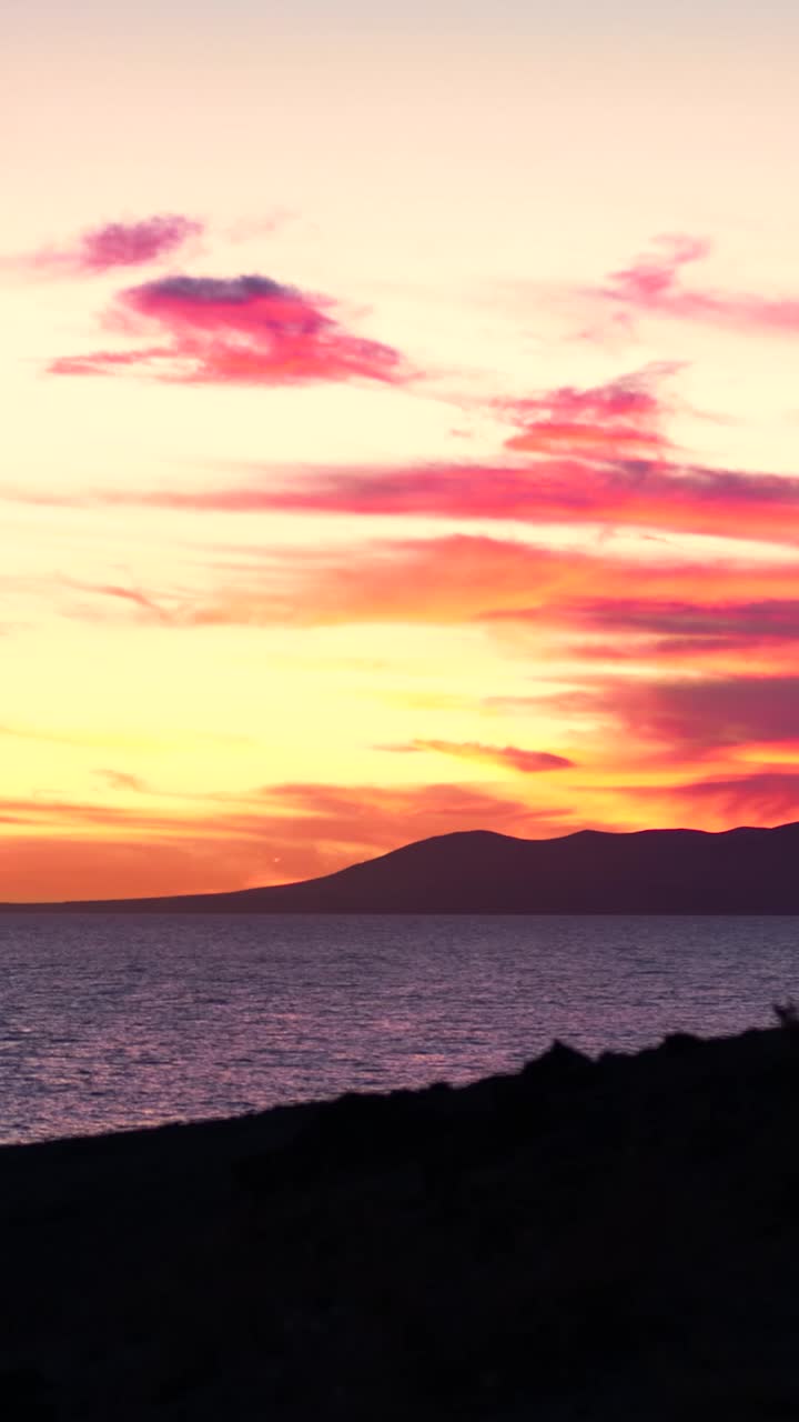 el atardecer vibrante sobre el océano con las montañas