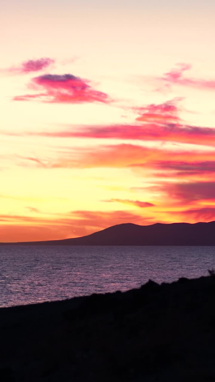 Vibrant Sunset Over the Ocean with Mountains
