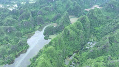 lush green karst mountains and calm river in ninh binh, vietnam, peaceful aerial view