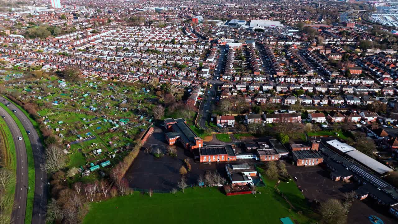 Luftfoto med drone fra høj vinkel over Millbrook forstadsboligområde i Southampton ved solnedgang, med træer, huse og natur omkring. Optaget om vinteren med trafik og biler på gaderne.