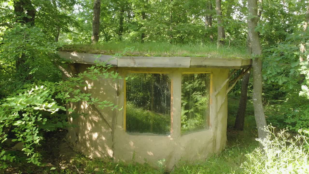 숲, 여름철, 불가리아에 잔디 지붕이 있는 작은 점토집의 느린 패닝 샷