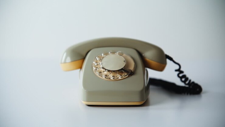 Gros plan d’un téléphone portable rétro de papeterie sur fond blanc. Rotatif vintage