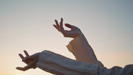 lady hands moving sunrise sky background closeup. unknown woman arms dancing