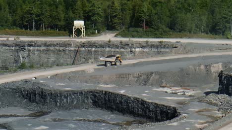 dump truck driving through quarry with coal fossil fuel load