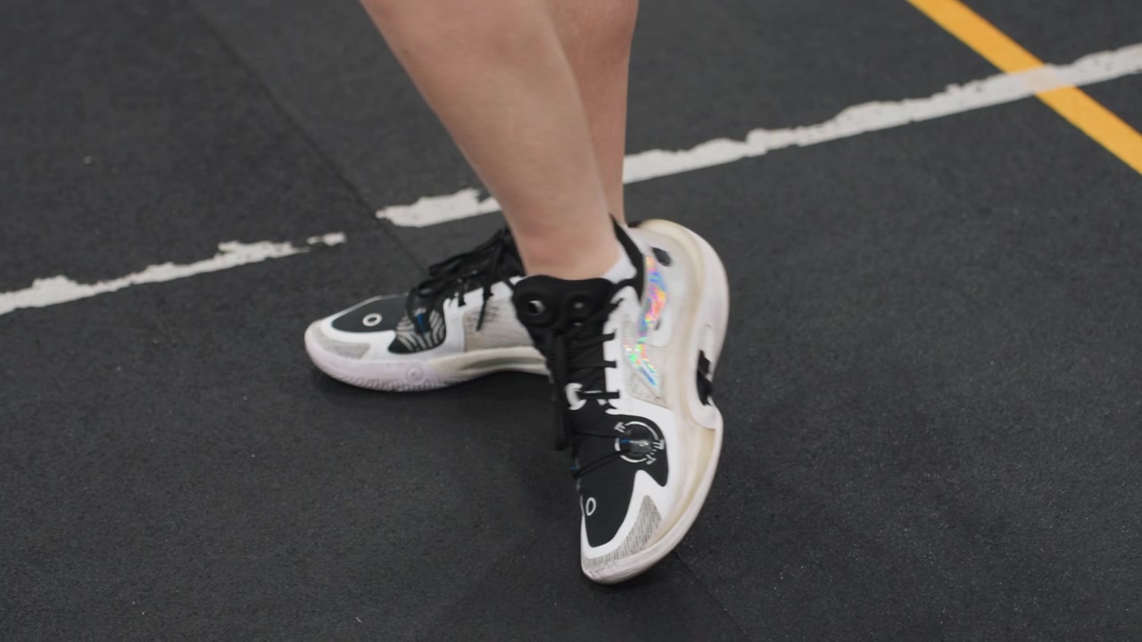 Scena di esercitazione sul gioco di gambe nel badminton. Primo piano di un gioco di gambe controllato e movimenti rapidi nel badminton. Immagine dettagliata che cattura la precisione e il tempismo degli esercizi di posizionamento dei piedi su un campo da pallavolo