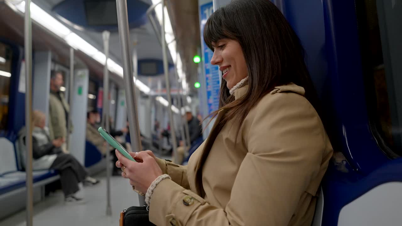 Smiling Woman Using Smartphone While Commuting on Subway Train