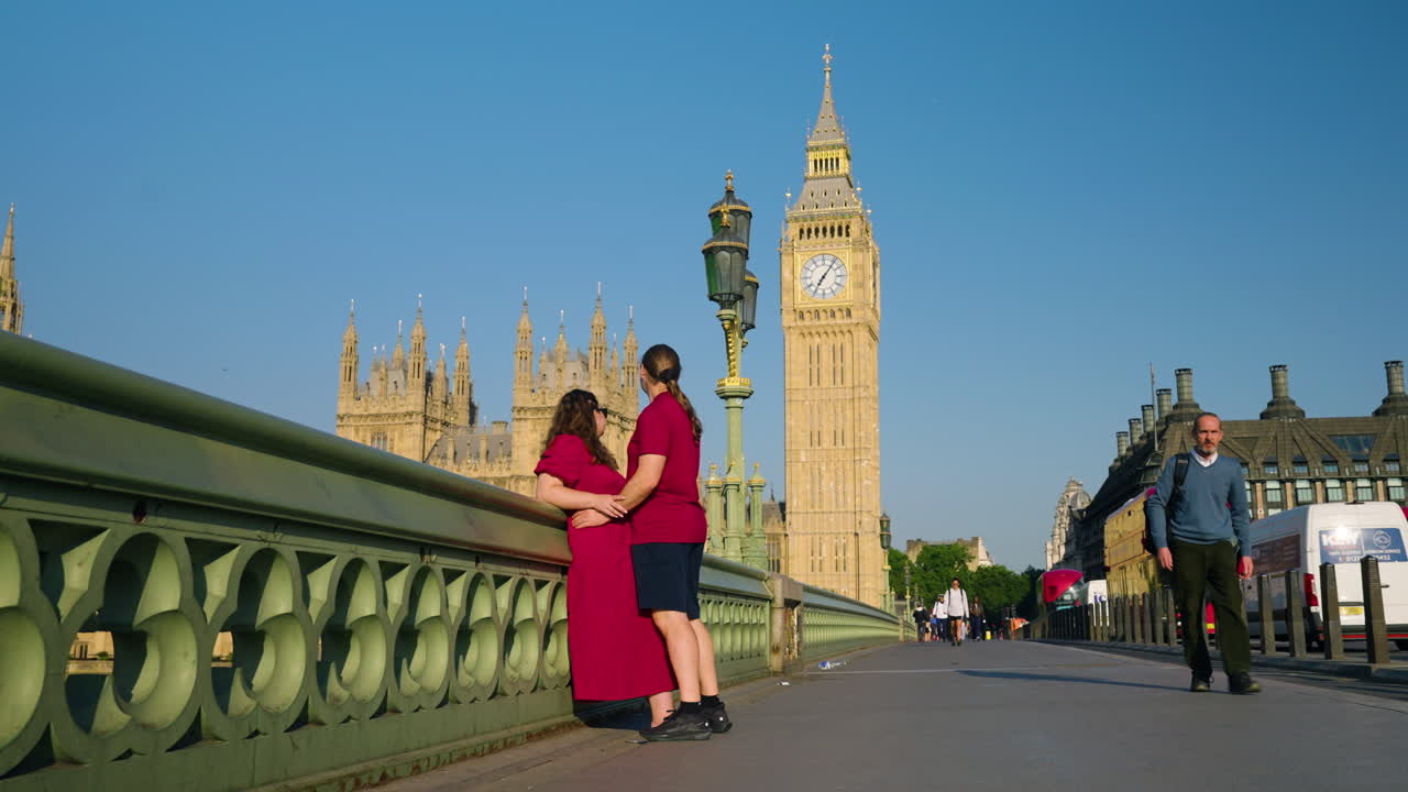 Sweet Couple On A Bridge, Parliament And Big Ben In The Background In London - Wide Shot