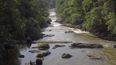 un hombre sentado en una cascada