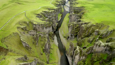 Drohnen-Luftaufnahmen,-Die-Durch-Die-Fjaðrárgljúfur-Schlucht-Mit-Einer-Riesigen,-100-M-Hohen-Steilwand-In-Südisland-Fliegen