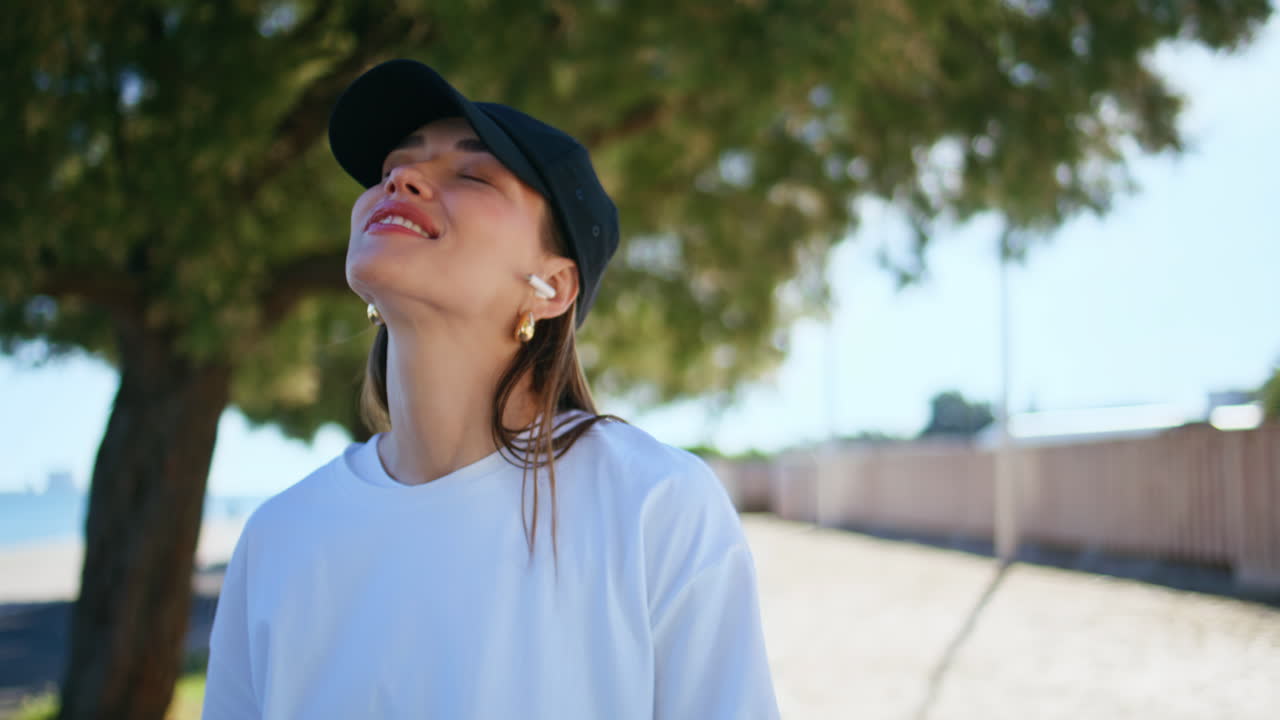 Joyful girl listening headphones music turning cellphone app at street closeup