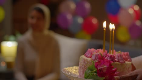 primer plano de amigos multiculturales dando a una mujer pastel de cumpleaños con velas en una fiesta en casa