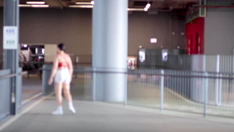 woman performs jumping jacks in a spacious mall