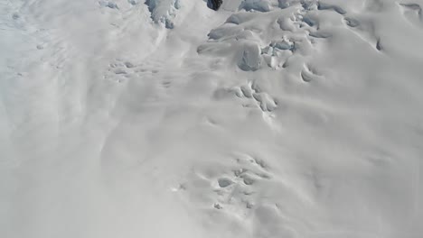 4k drone flying forward and panning up from glacier to jagged mountaintops