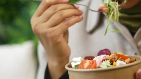 woman eating a mixed green salad