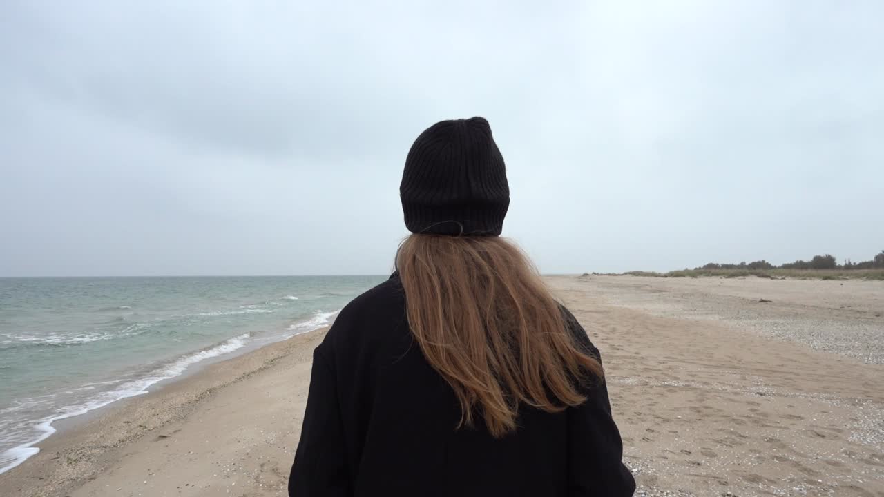 The girl walks on the beach. Shooting on the beach