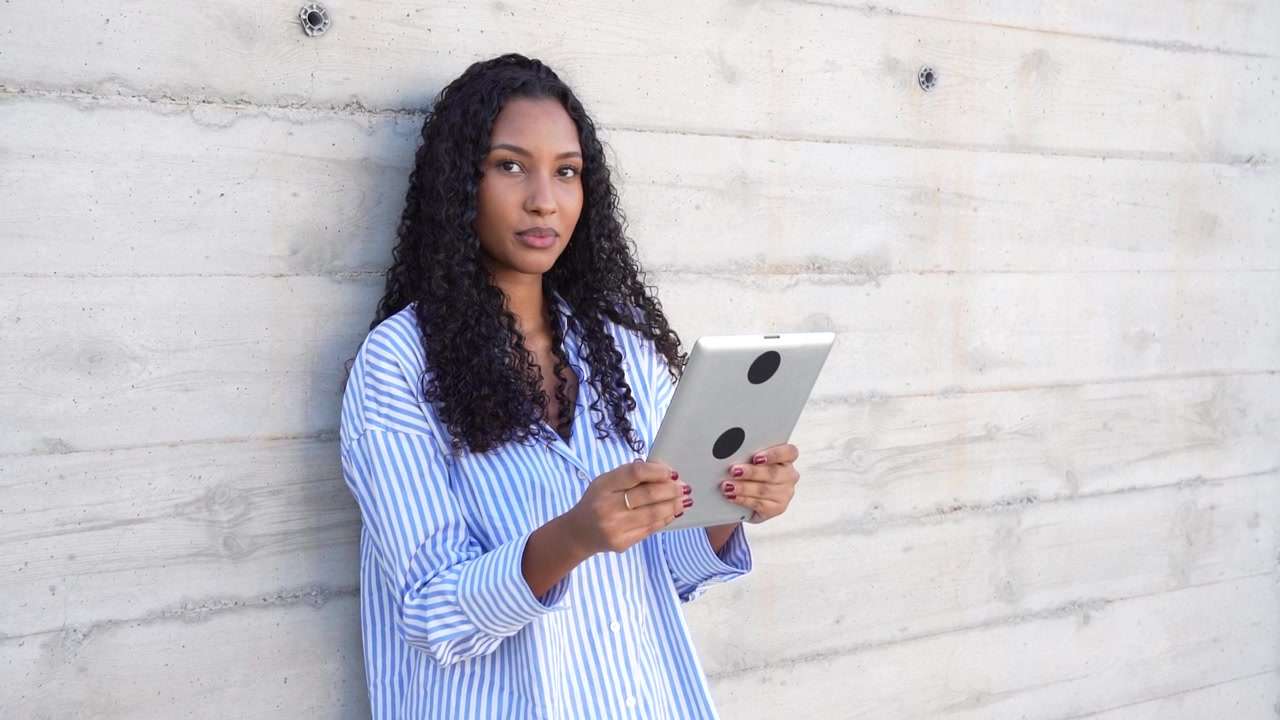 Una donna usa il suo tablet in un ambiente moderno, evidenziando la fusione tra tecnologia e stile di vita.