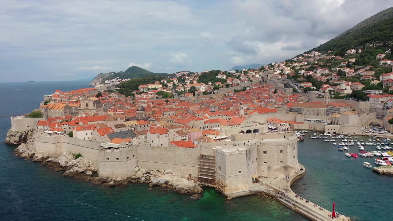 Fantastisk droneudsigt over den historiske rødtagede gamle bydel i Dubrovnik. Med gamle stenmure, kystklipper og det turkise Adriaterhav. Et verdensberømt middelhavslandemærke og UNESCO-sted.
