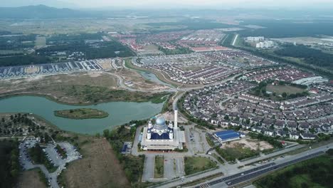 aerial view masjid abdullah surrounded by a lake