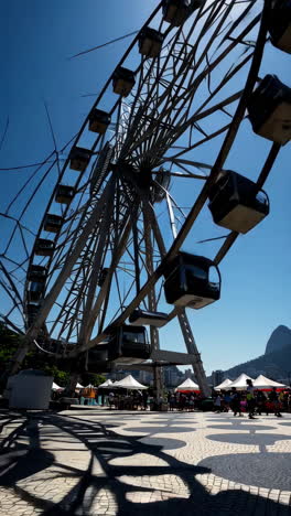 ferris wheel and market scene in rio de janeiro with sugarloaf mountain