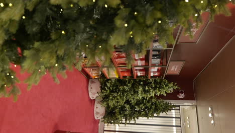 vertical shot of christmas trees displayed at shopping mall store, handheld