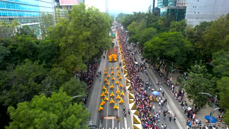 overhead drone shot of the day of the dead parade in mexico city with people in costumes