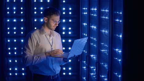 ingeniero de servidor masculino en un centro de datos. ingeniero de it inspeccionando un gabinete de servidor seguro usando tecnología moderna laptop coworking en un centro de datos.