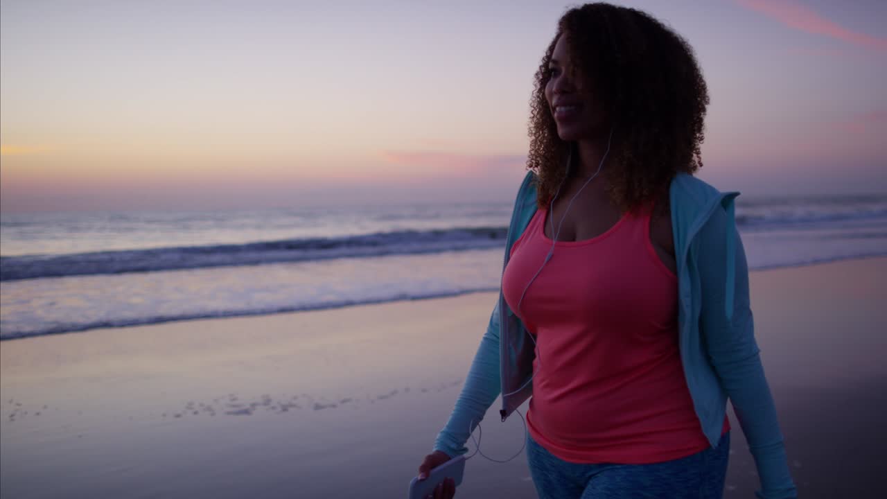 Afroamerikanische Frau trainiert in Sportkleidung am Strand