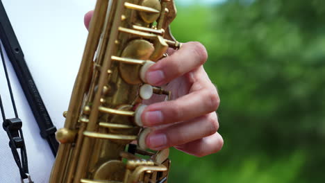 close up of hands playing saxophone