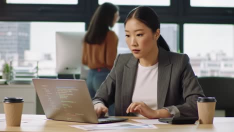 focused software developer engages in coding tasks at a modern workspace, balancing productivity and innovation as she collaborates with team members