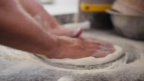 chef modeling the pizza dough with flour