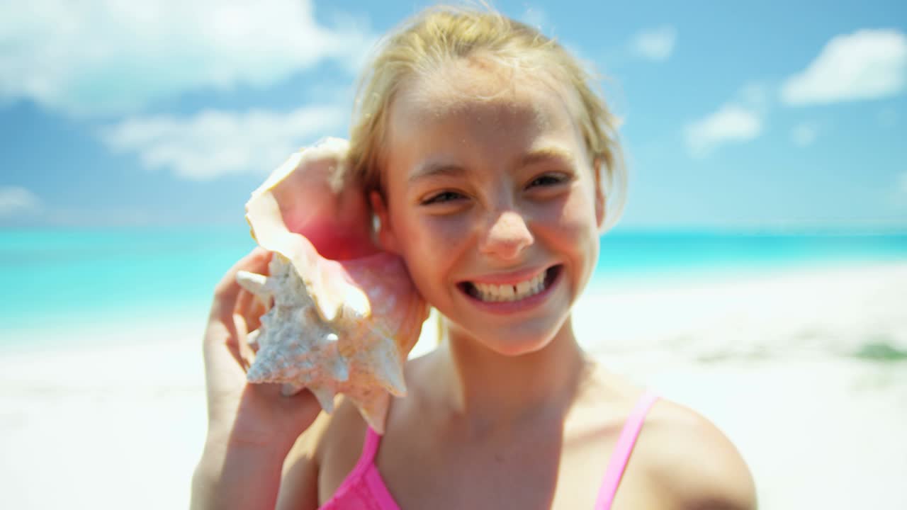 Portrait of girl on beach with conch shell