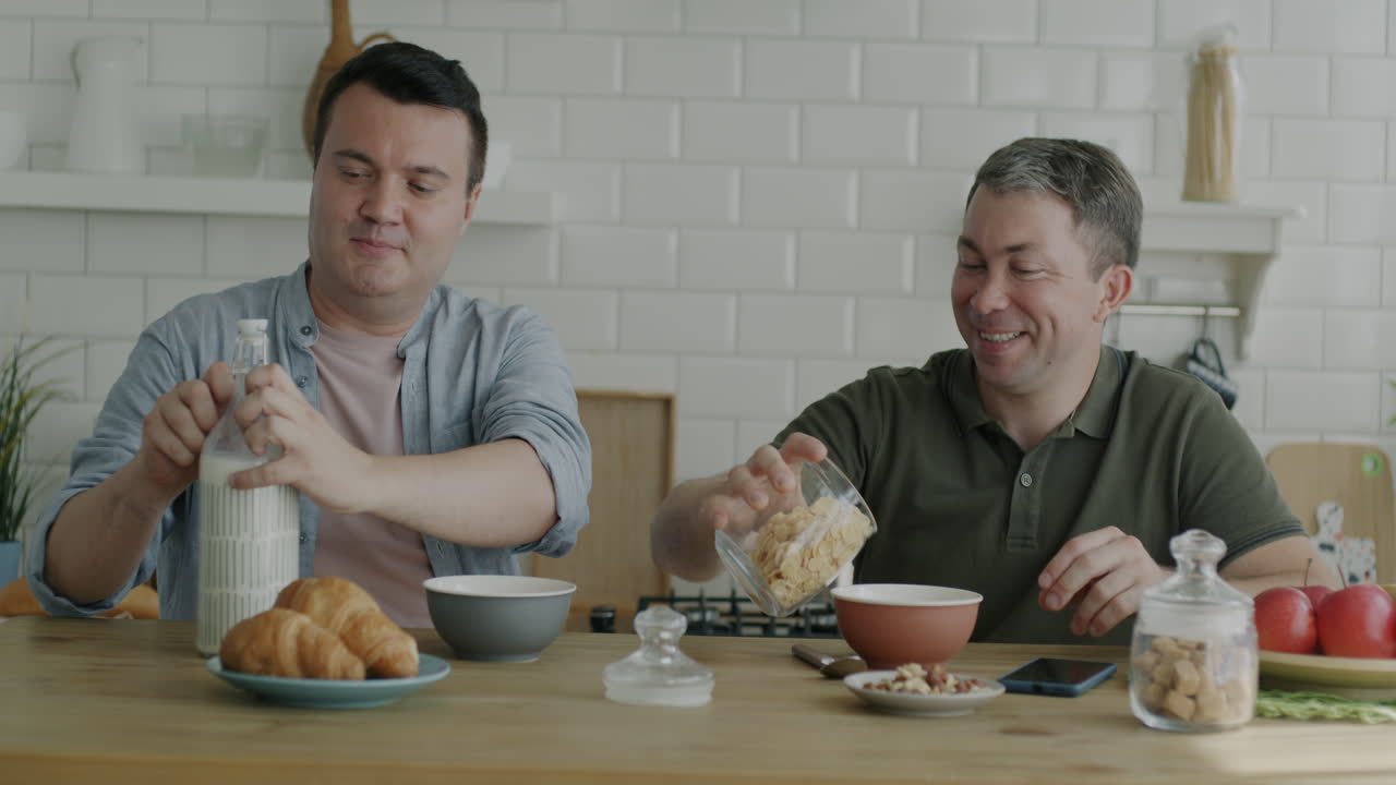 Two men having breakfast together in a kitchen.