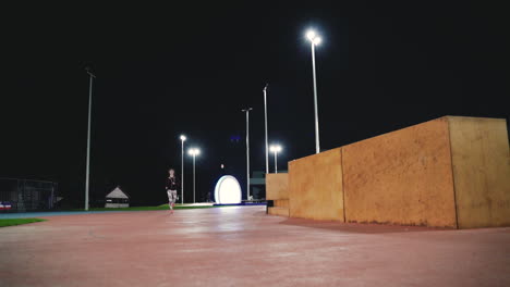 sportive sportswoman using bluetooth headphones running fast in the park at night