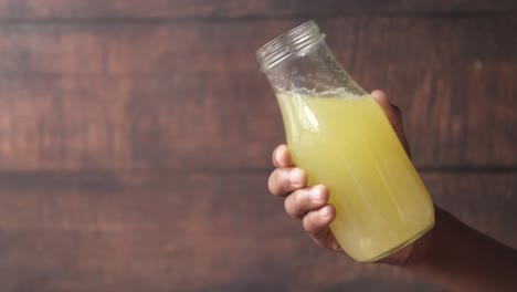 hand holding a bottle of sugarcane juice