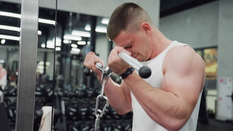 athlete grips cable machine handle in modern gym and powers through intense arm curl set, brow furrowed, muscles flexing, reflecting disciplined strength training routine in fitness center