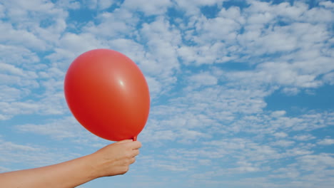 Luft-Kommt-Aus-Dem-Roten-Luftballon-Und-Wird-Schlaff-Vor-Dem-Hintergrund-Des-Blauen-Himmels