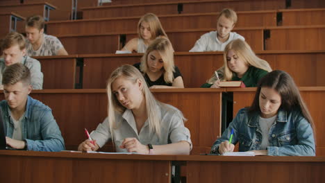 young successful students in a large university class listen and record a lecture a real lecture at the university.