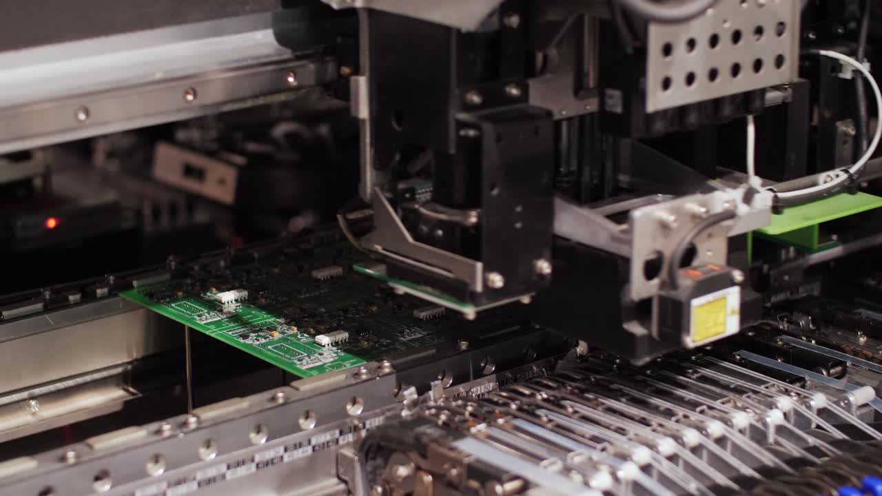 Precision machinery in action on an automated assembly line, placing components onto printed circuit boards with high accuracy