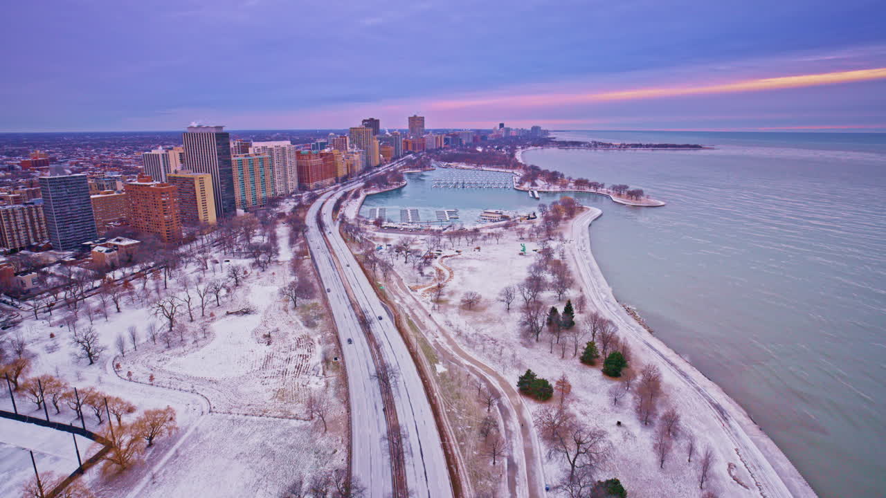 Prise de vue cinématographique par drone au lever du soleil sur le quartier du Loop du centre-ville de Chicago, avec l'horizon et le lac Michigan visibles