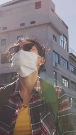 biracial woman wearing medical coronavirus mask on the street