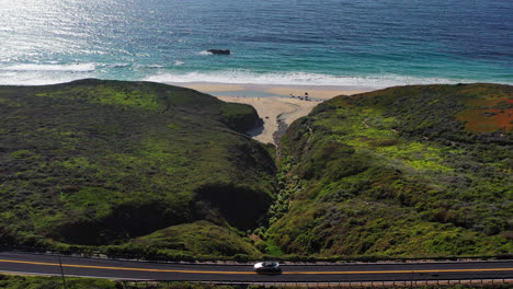 Flying-around-green-hills-with-white-blooming-lilies-by-the-sand-beach