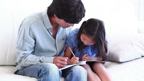 Father-watching-his-daughter-colouring