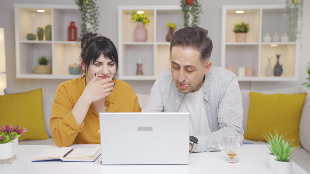 La pareja que mira el portátil se enoja
