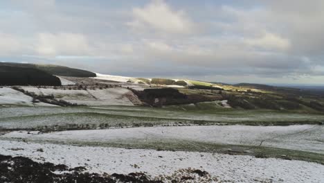 verschneite ländliche wintertallandschaft luftaufnahme landwirtschaftliches ackerland landschaft langsam nach rechts schwenken