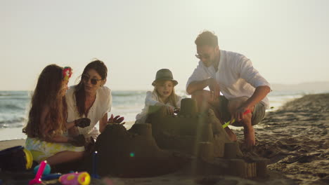 family building sandcastles on the beach