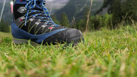 shoe of a hiker on the ground in the mountains in a grass field, swiss alps, obwalden