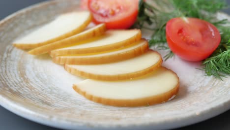 sliced cheese with tomatoes and dill