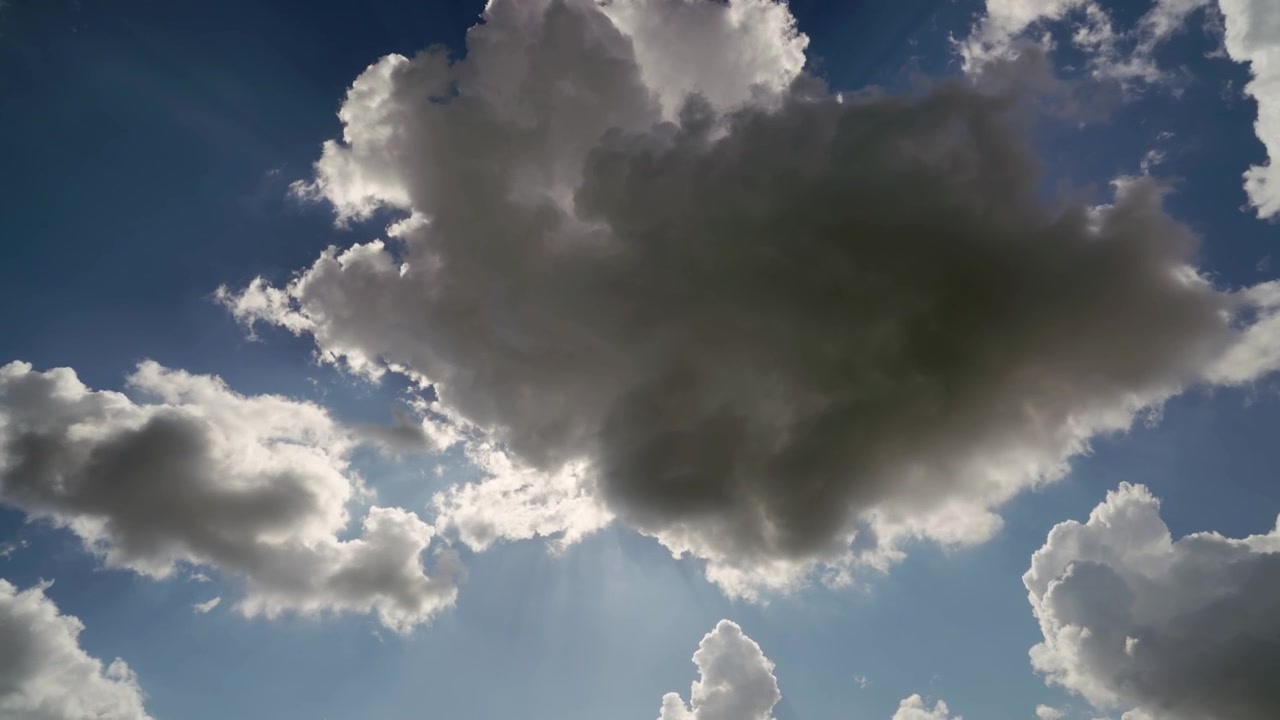 Raios de Sol Através de Nuvens em Movimento no Céu Azul